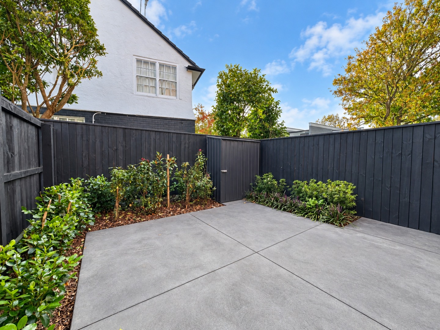 Modern Landscaped Courtyard with Dark Fence
