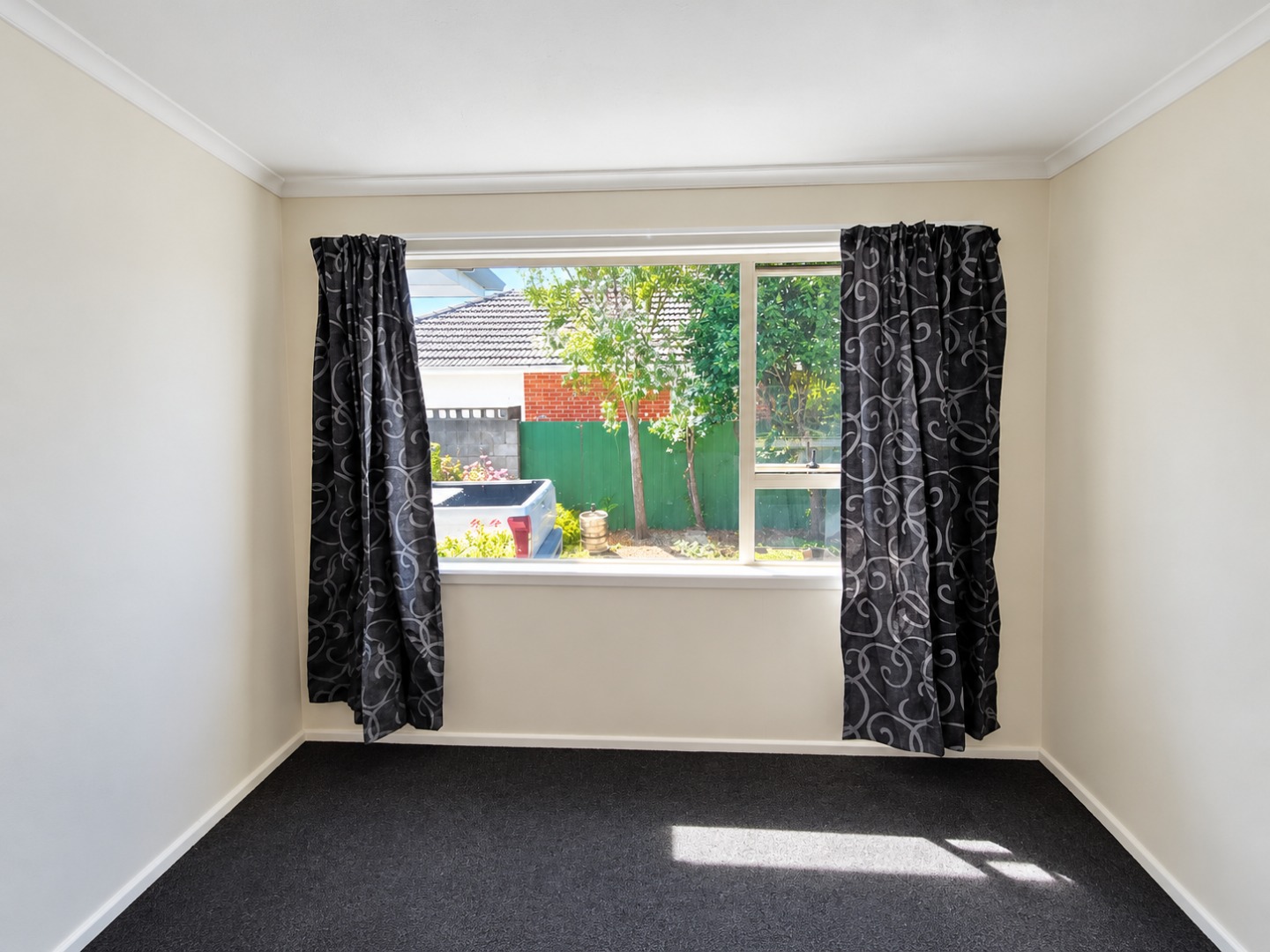 Sunlit Empty Room with Patterned Curtains