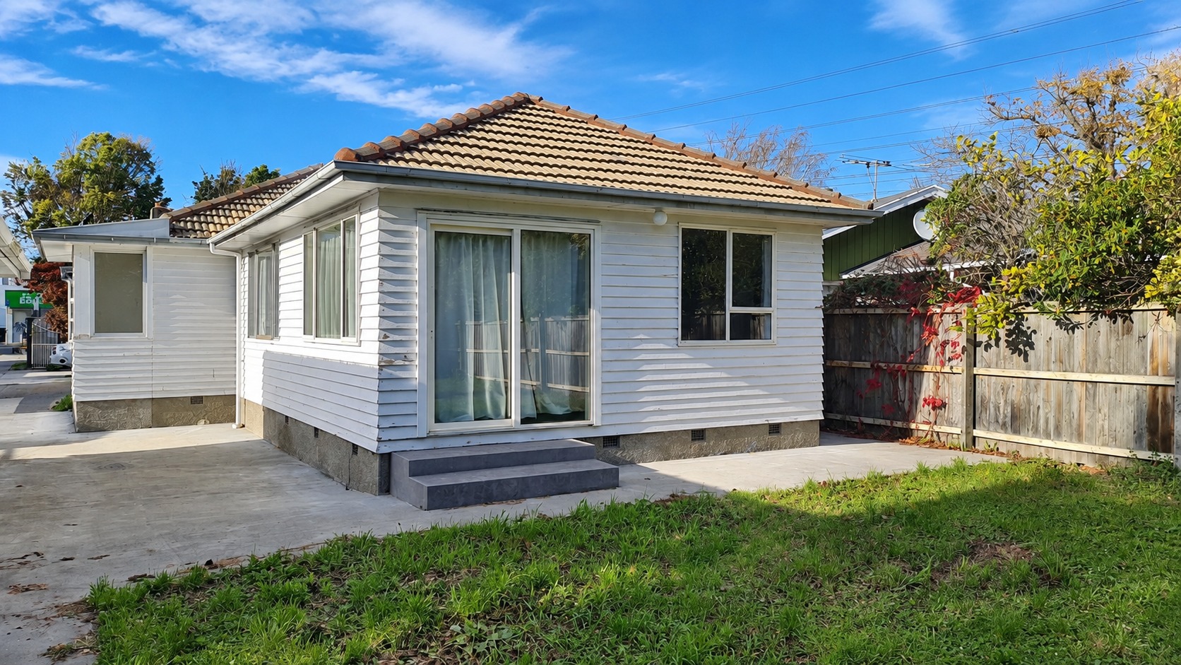 Sunny Suburban Backyard with White Weatherboard House
