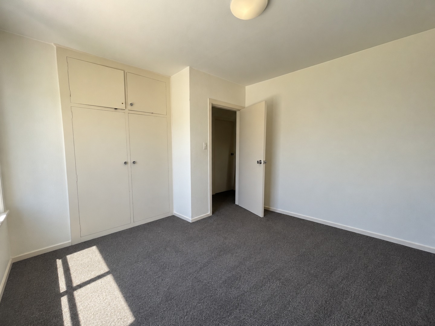 Sunlit Empty Bedroom with Built-In Closet