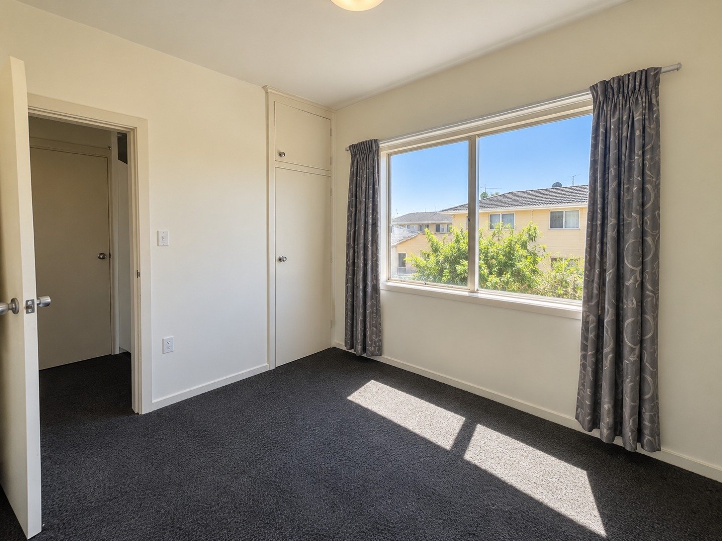 Bright Empty Bedroom with Window and Built-Ins