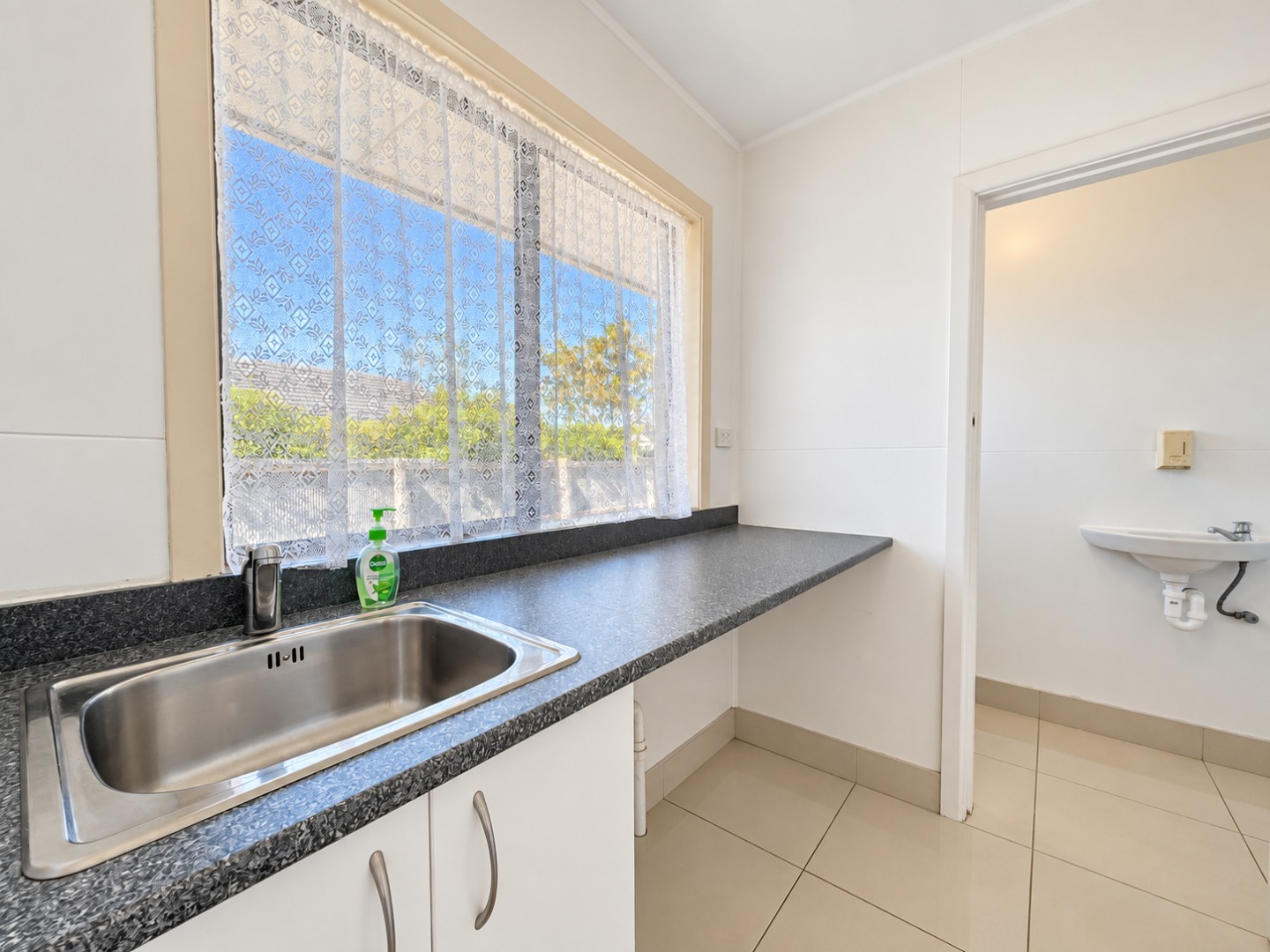Bright Minimalist Laundry Kitchen with Lace-Curtained Window