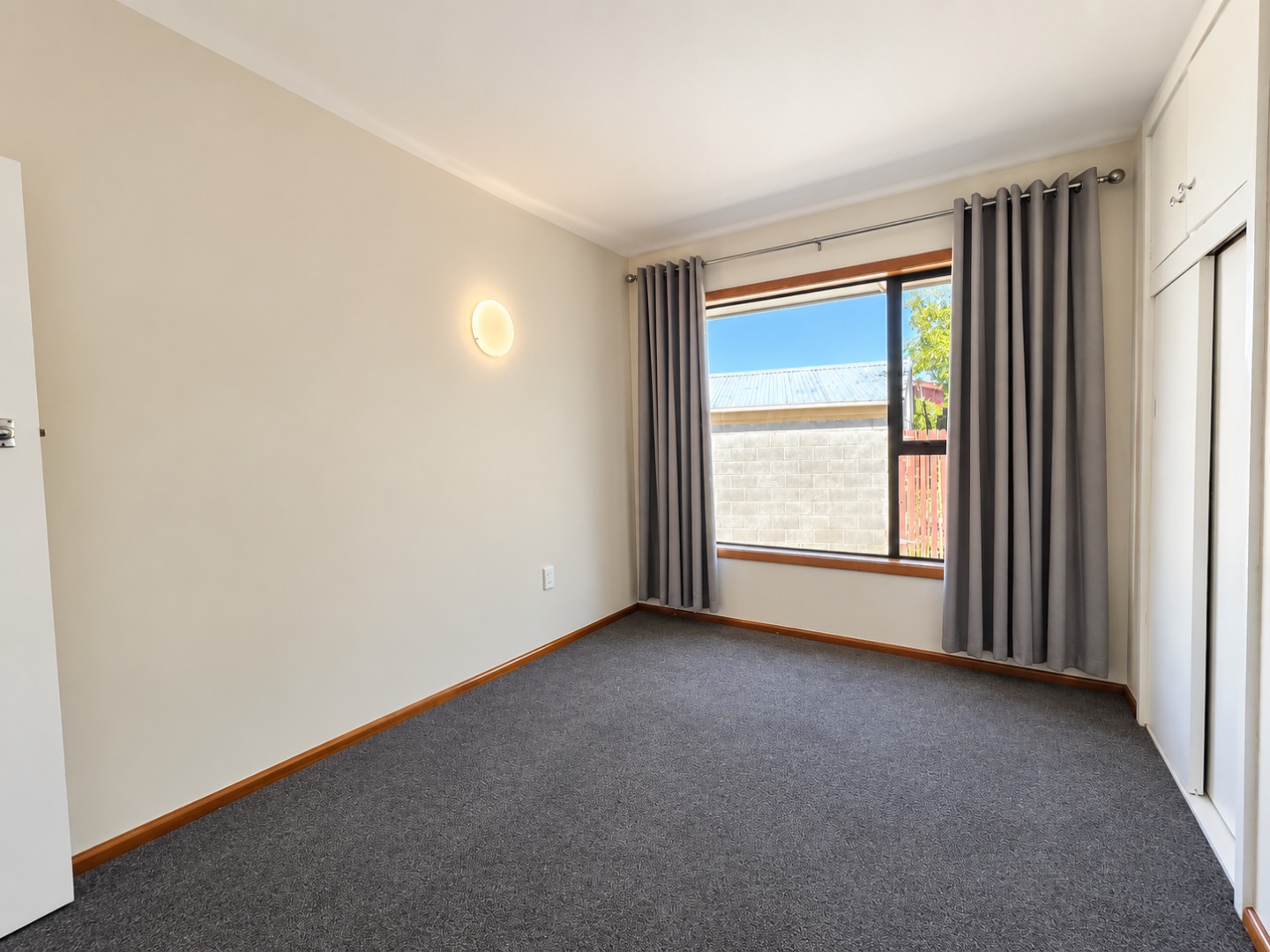 Bright Empty Bedroom with Window and Sconce